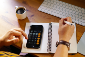 Imagem de agenda e celular com calculadora aberta representando o cálculo de DIFAL ICMS
