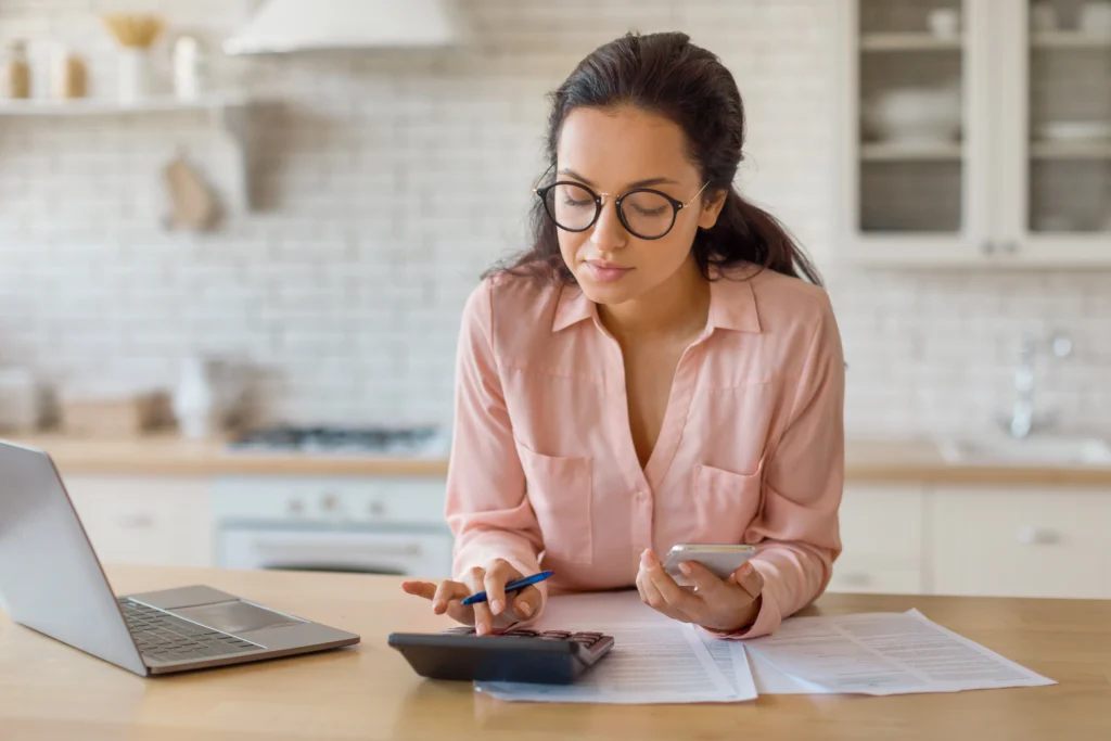 Mulher mexendo na calculadora representando contador declarando imposto de renda